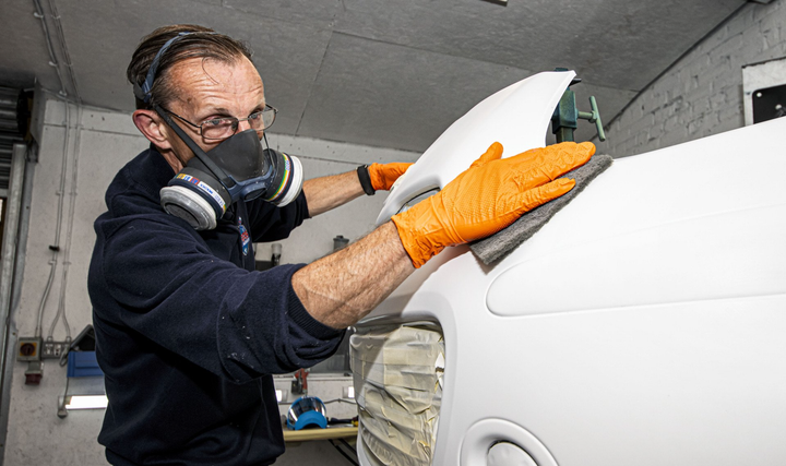 mechanic fitting body panel for respray
