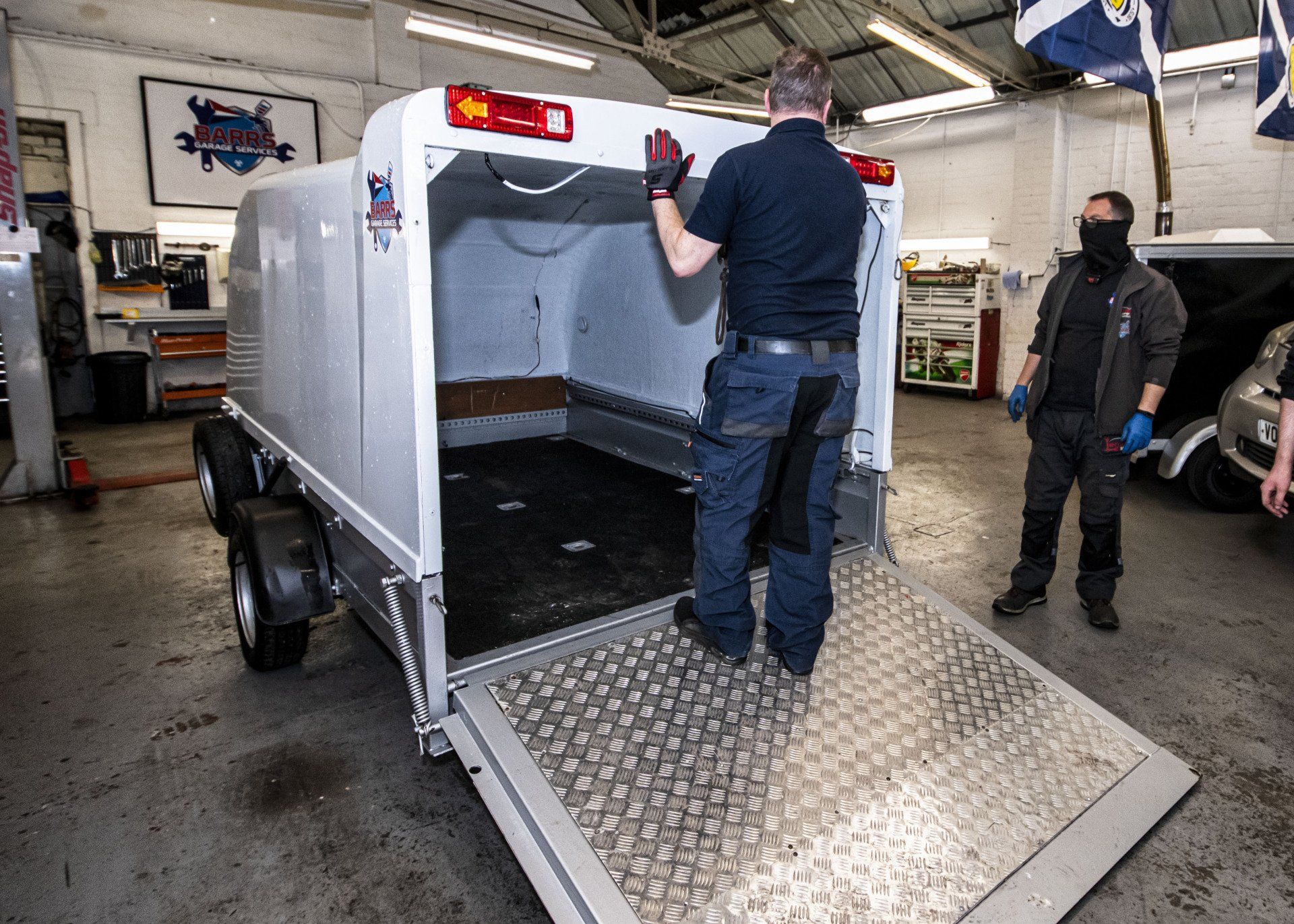 mechanic opening motorbike trailer
