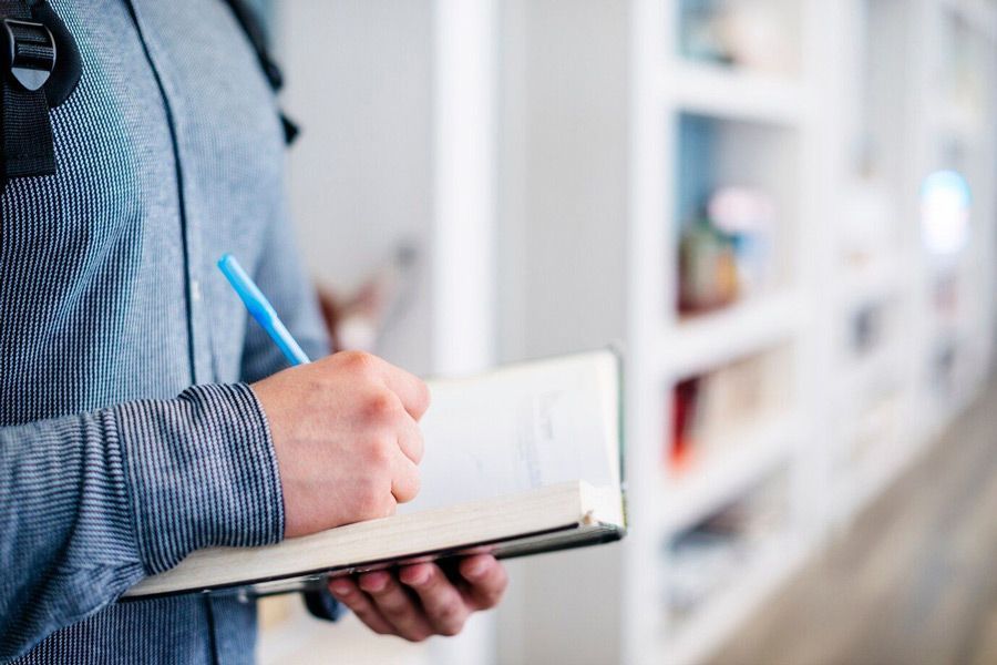 A man is holding a clipboard and writing on it.