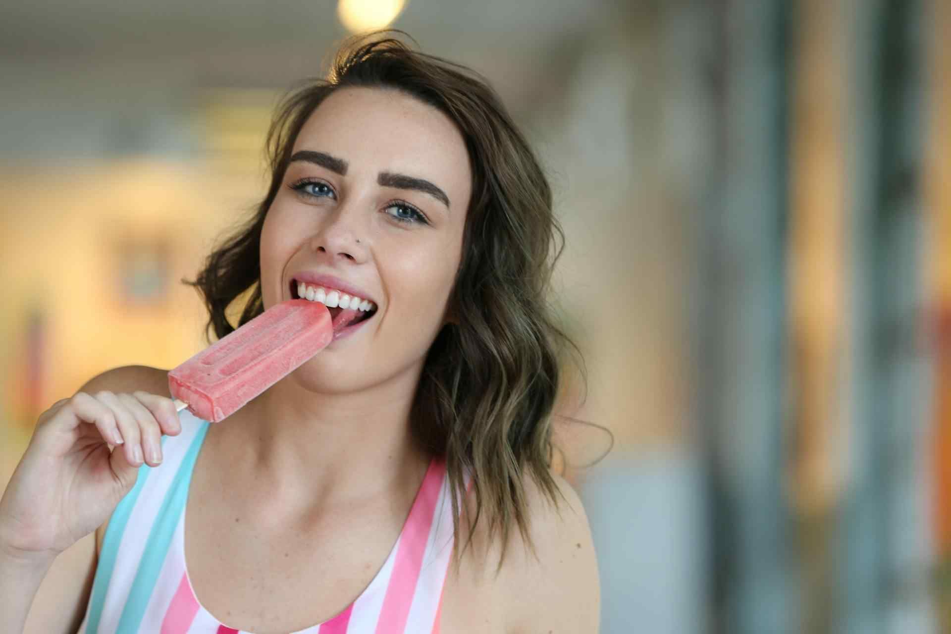 A Woman Enjoying A Cherry Flavored Popsicle