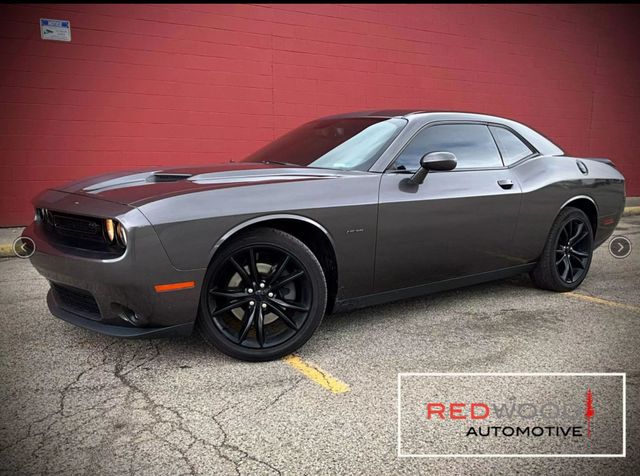 Gray Dodge Challenger parked in front of a red wall. Black rims, Redwood Automotive logo. | Redwood Automotive