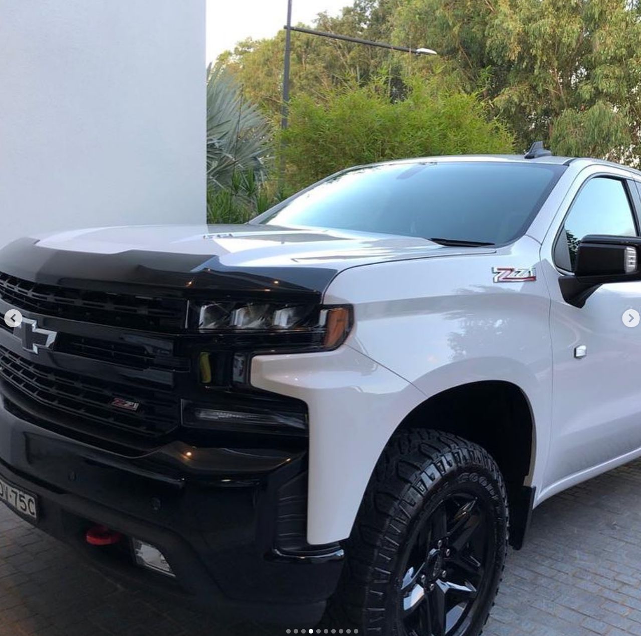 A white truck is parked in front of a building.