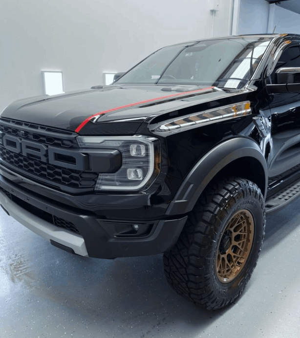 A black ford truck is parked in a garage with ceramic coating