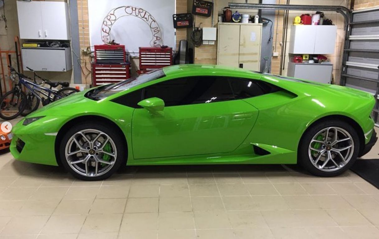 A green lamborghini huracan is parked in a garage.