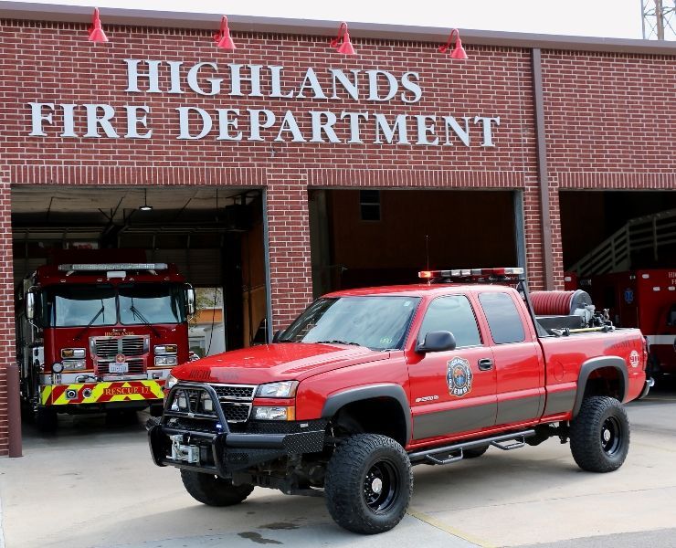 A red brush fire truck is parked in front of the highlands fire department