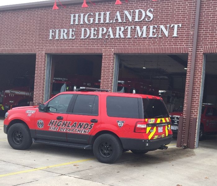 A red Highlands fire department vehicle is parked in front of a Highlands fire station