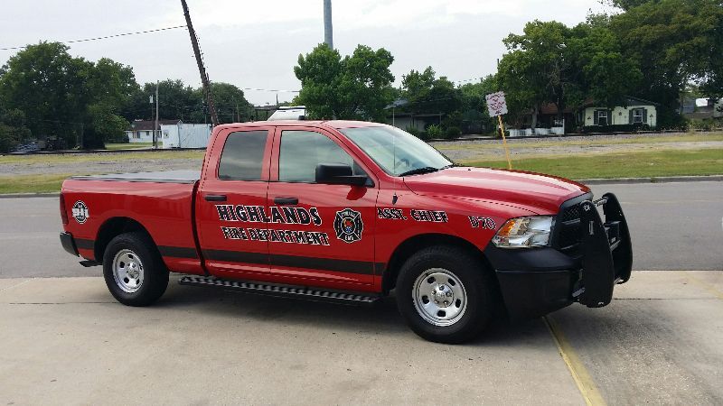A red fire command truck is parked on the side of the road