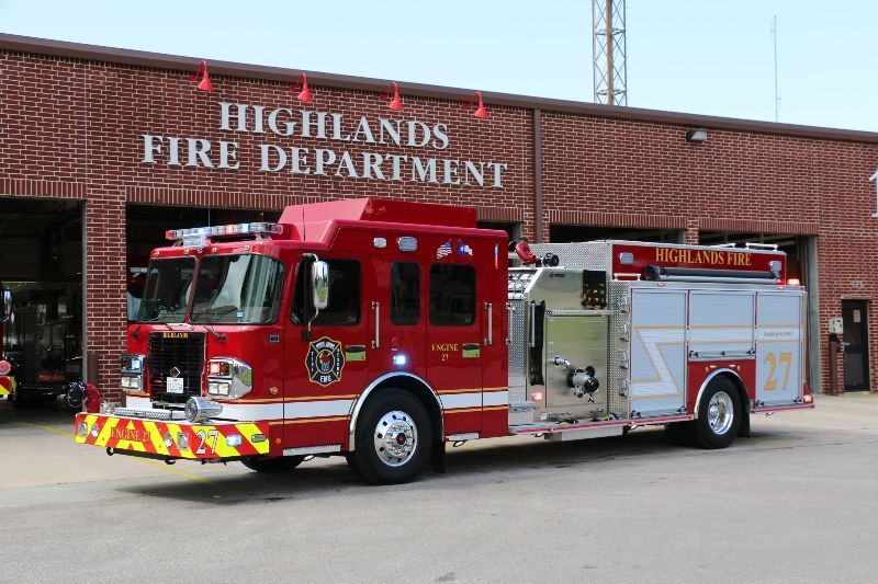 A red fire truck is parked in front of the Highlands fire department.