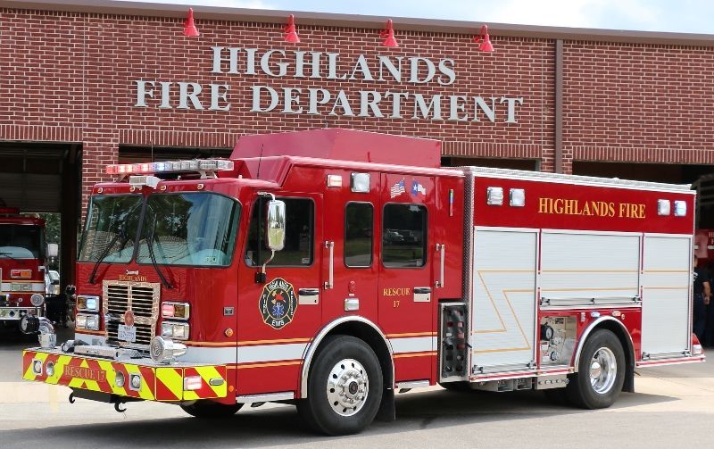 A red fire truck is parked in front of the Highlands fire department