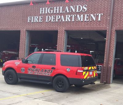 A red Highlands fire department vehicle is parked in front of a fire station