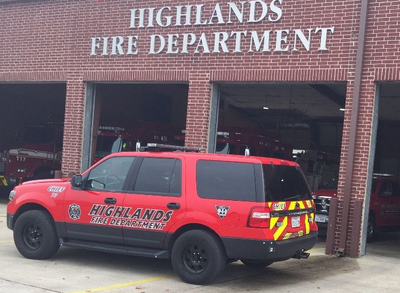 A red Highlands fire department vehicle is parked in front of a fire station