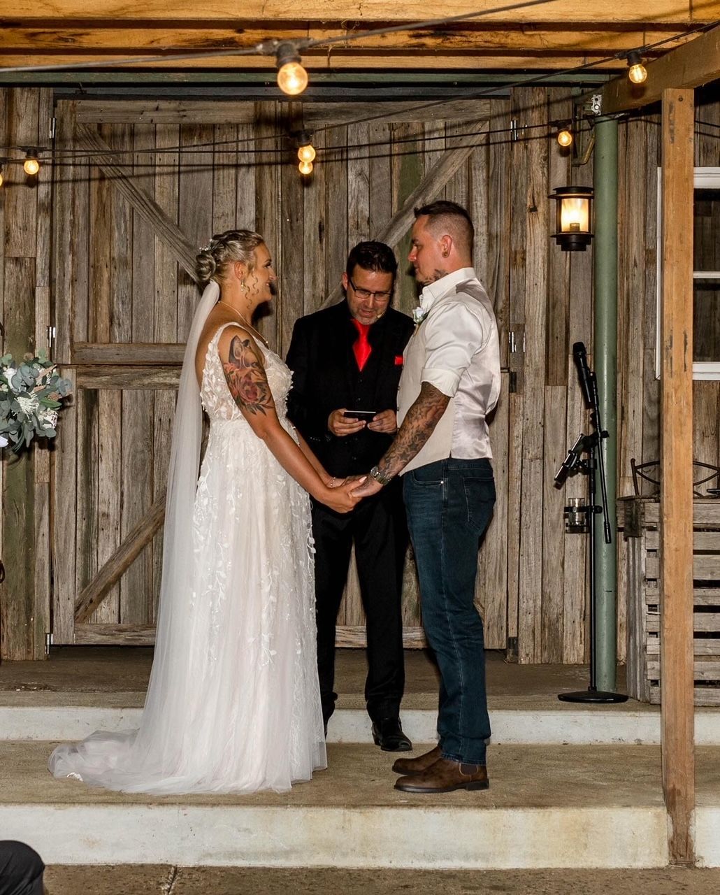 Bride and groom holding hands during an outdoor wedding ceremony with an officiant