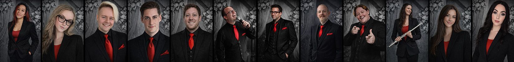 Group of people in dark red and black outfits posing in a row against a dark background