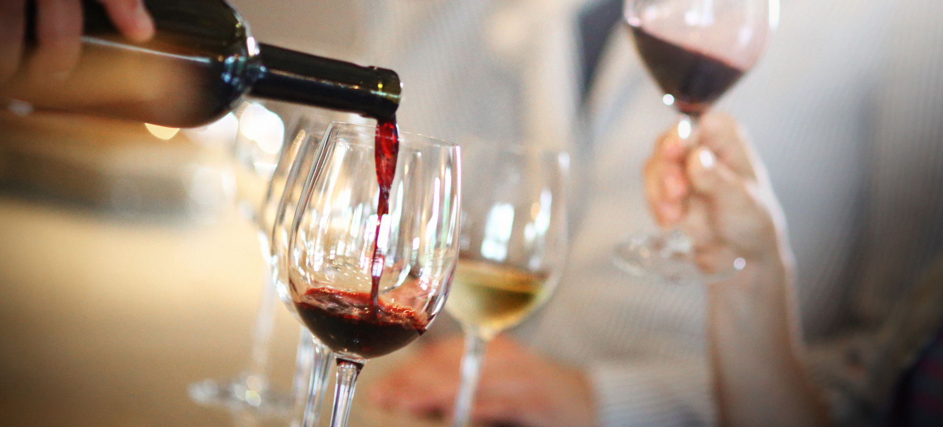 Someone pouring red wine into a glass