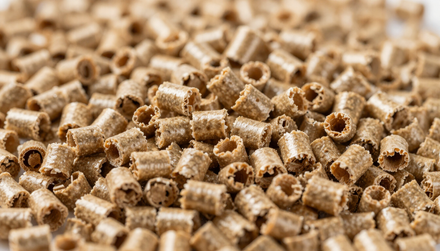 Cumulo di pellet di legno cilindrici color marrone chiaro che riempiono la struttura