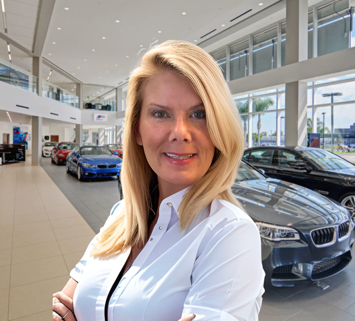 Woman in a white shirt smiles in a car dealership, cars in the background.