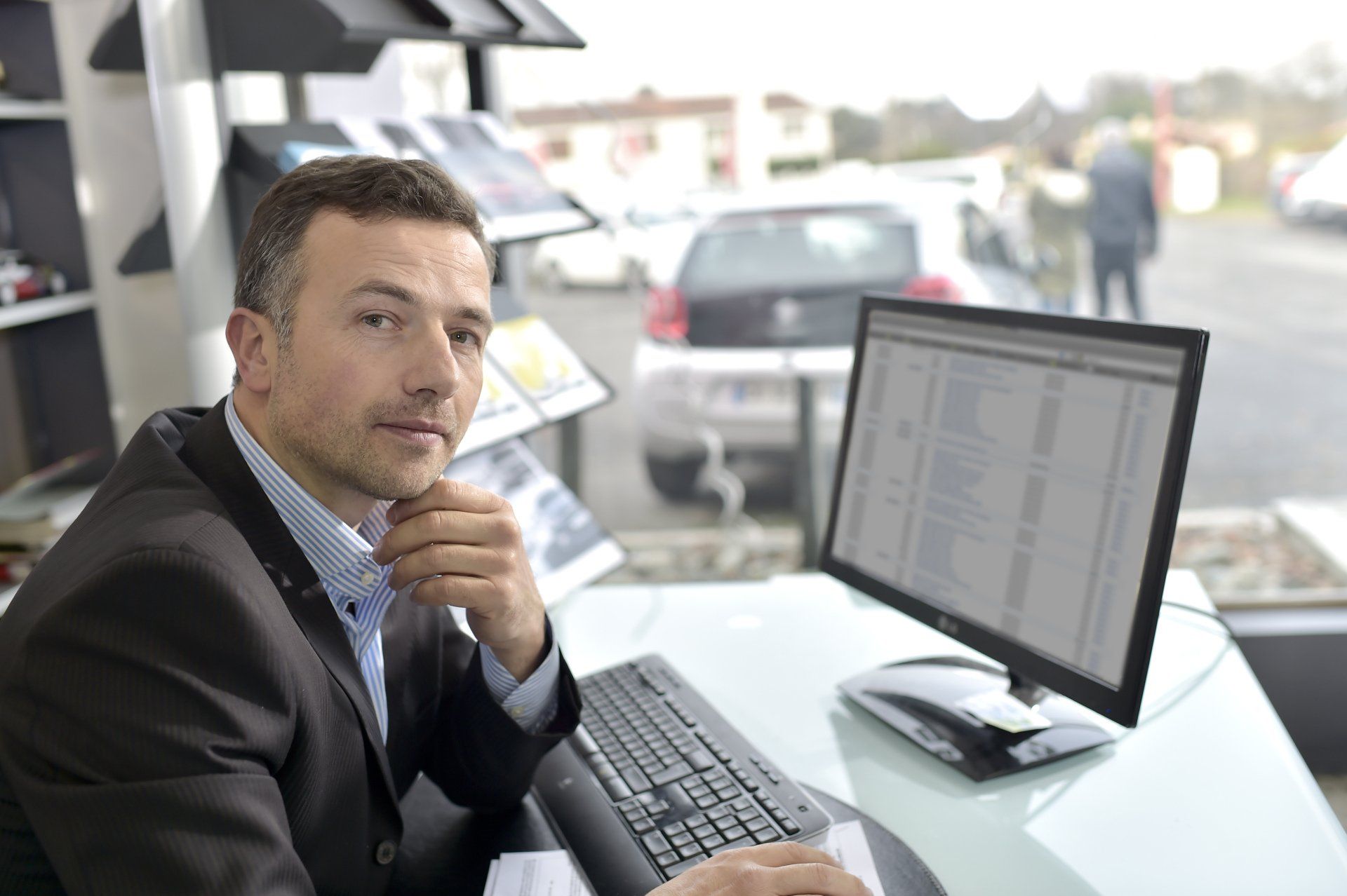 A man is sitting at a desk in front of a computer.