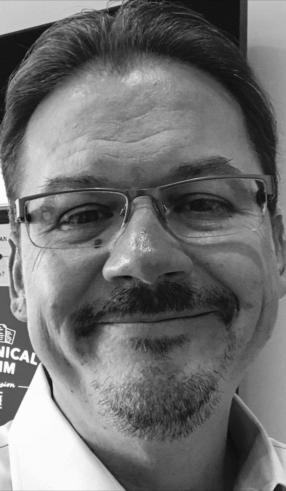 Man with glasses and mustache, smiling at the camera.
