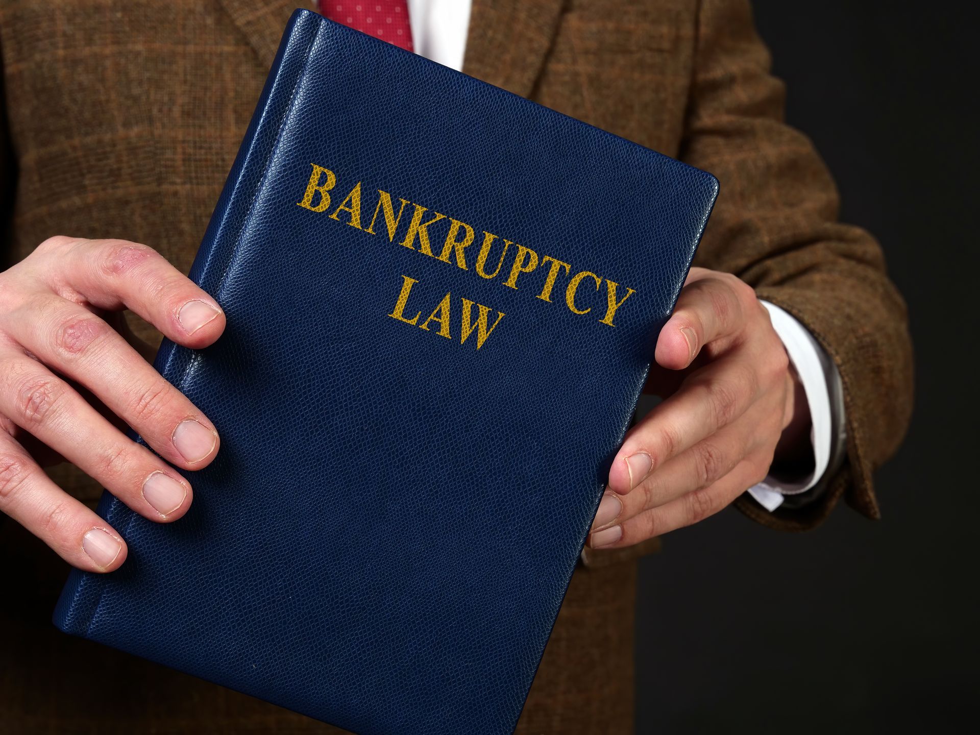 Person holding a blue book labeled
