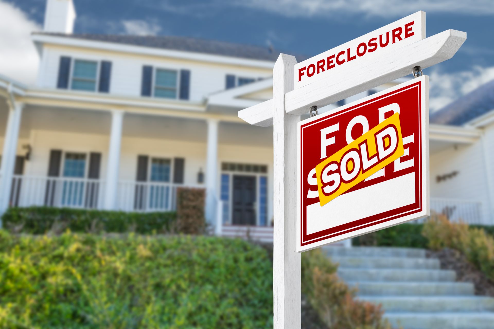 There is a foreclosure sign in front of a house.