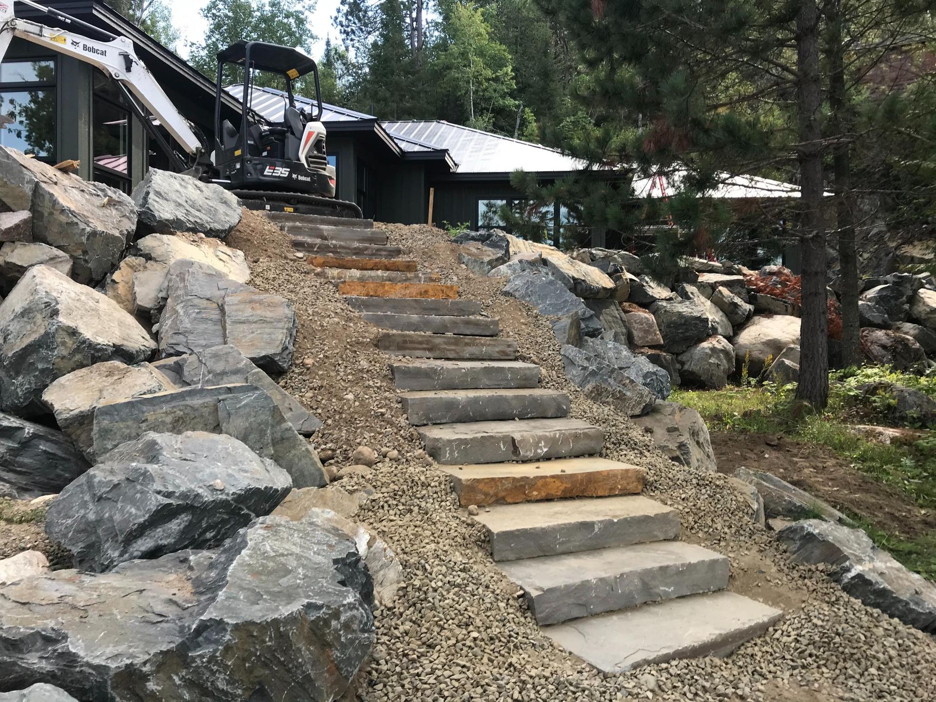 A set of stairs leading up to a house surrounded by rocks.