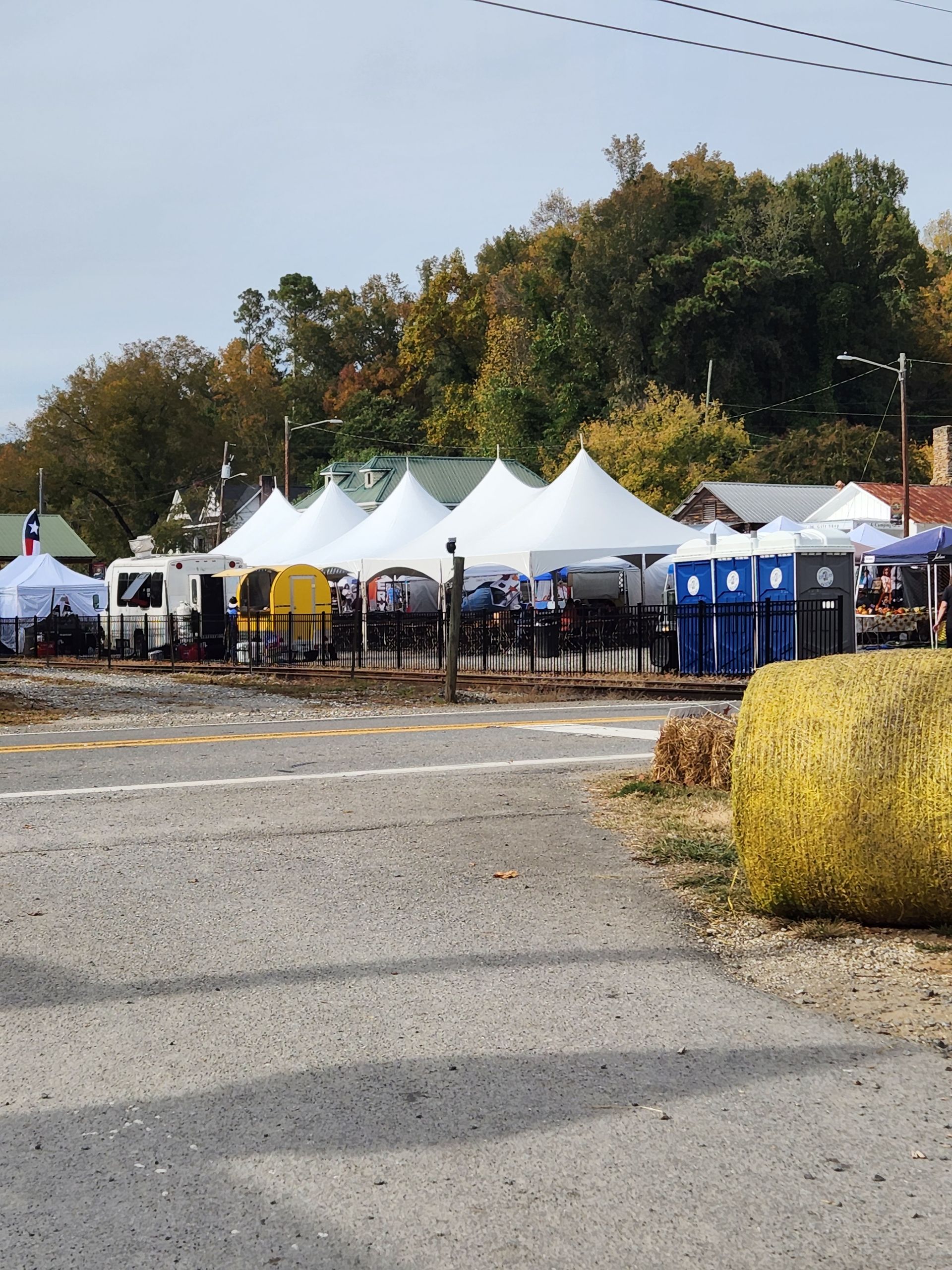 A bunch of tents are lined up in a parking lot