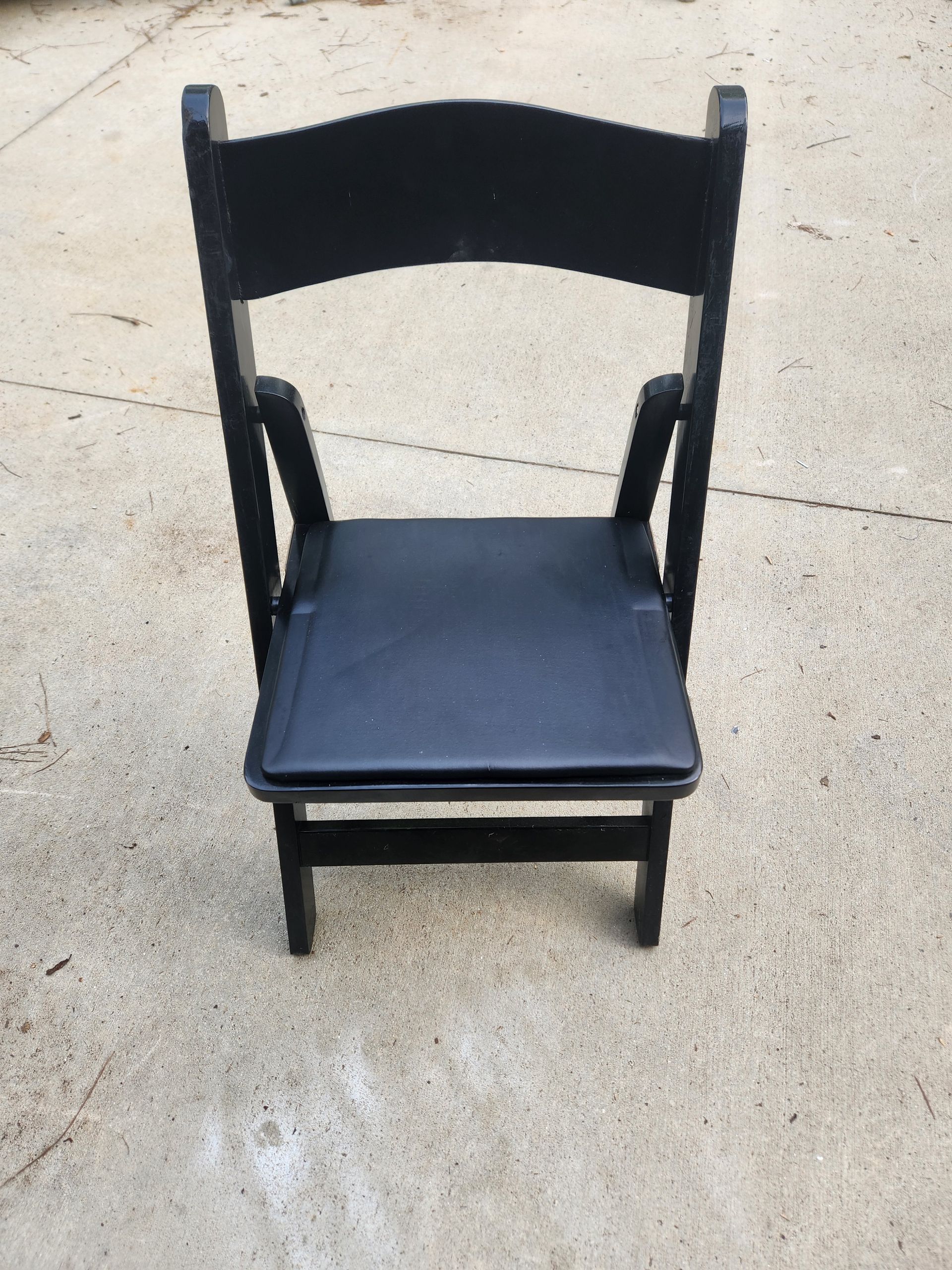 A black chair is sitting on a concrete surface