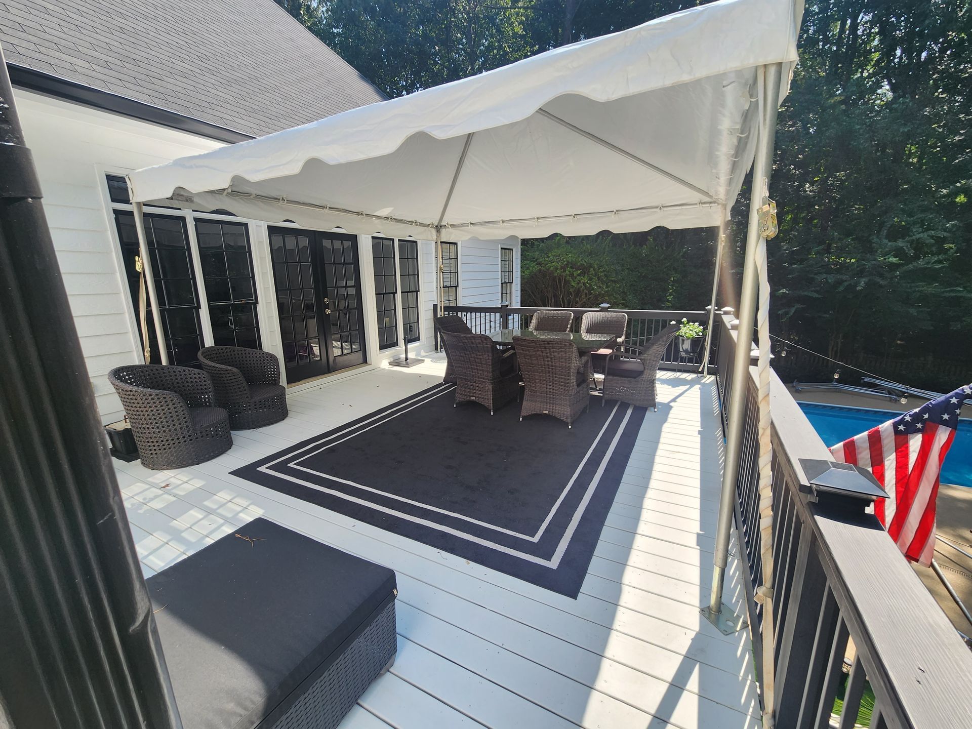 A deck with a table and chairs under a tent.