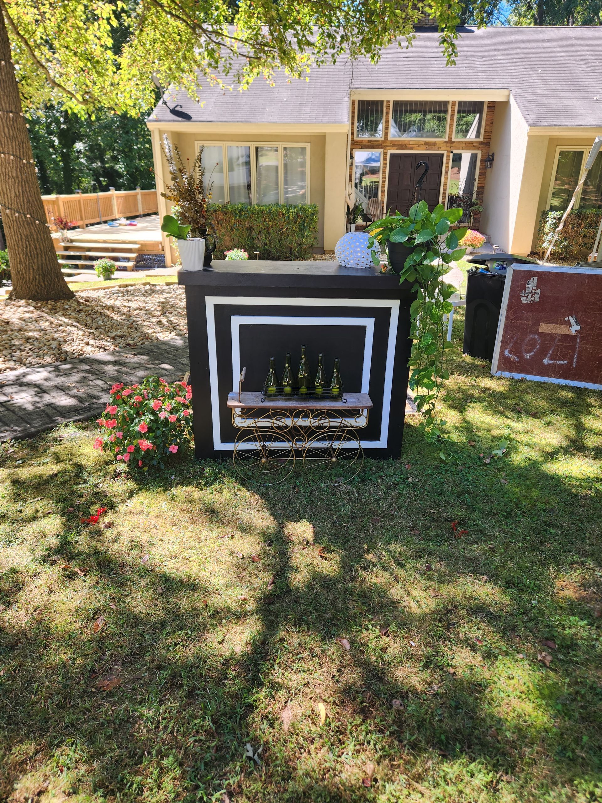 A fireplace is sitting in the grass in front of a house.