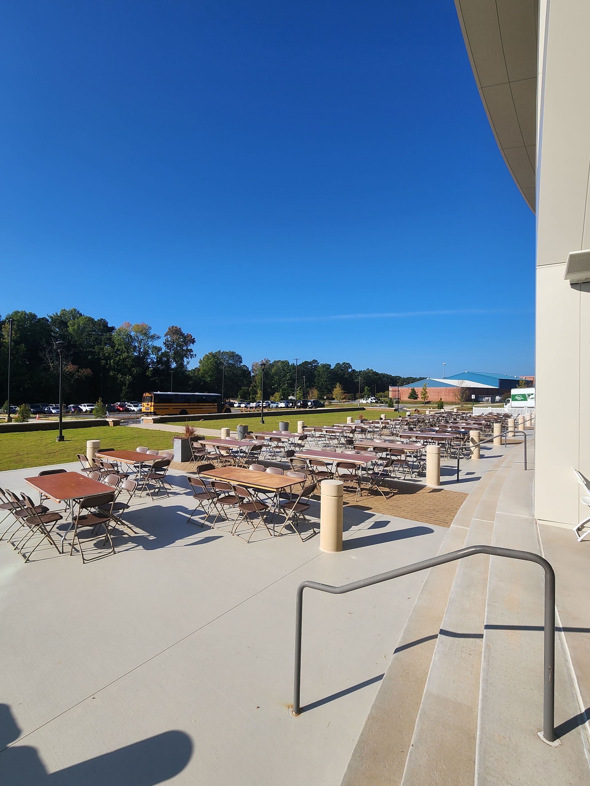 A patio with tables and chairs on a sunny day