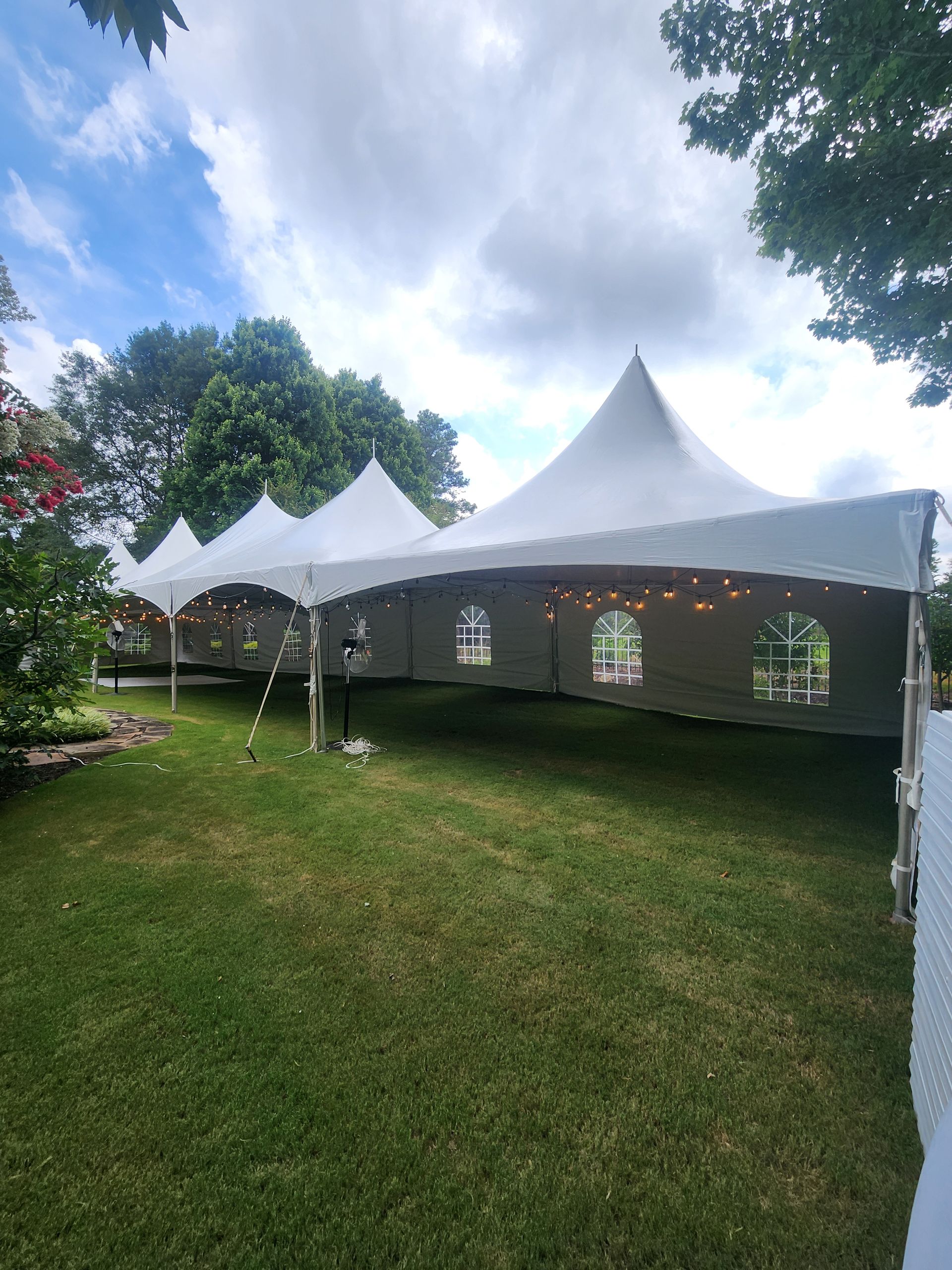 A white tent with tables and chairs in a park