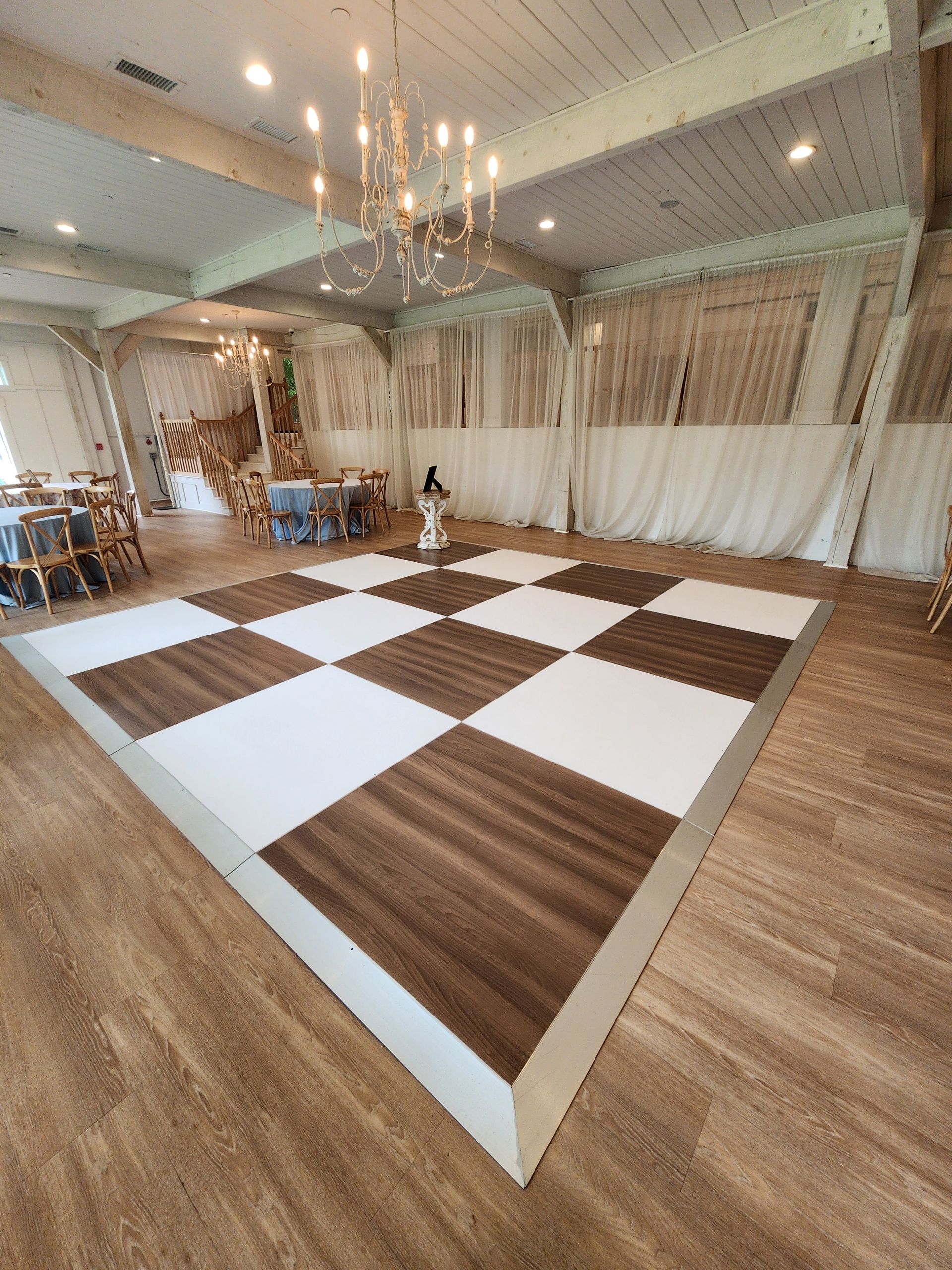 A large room with a wooden floor and a checkered dance floor.