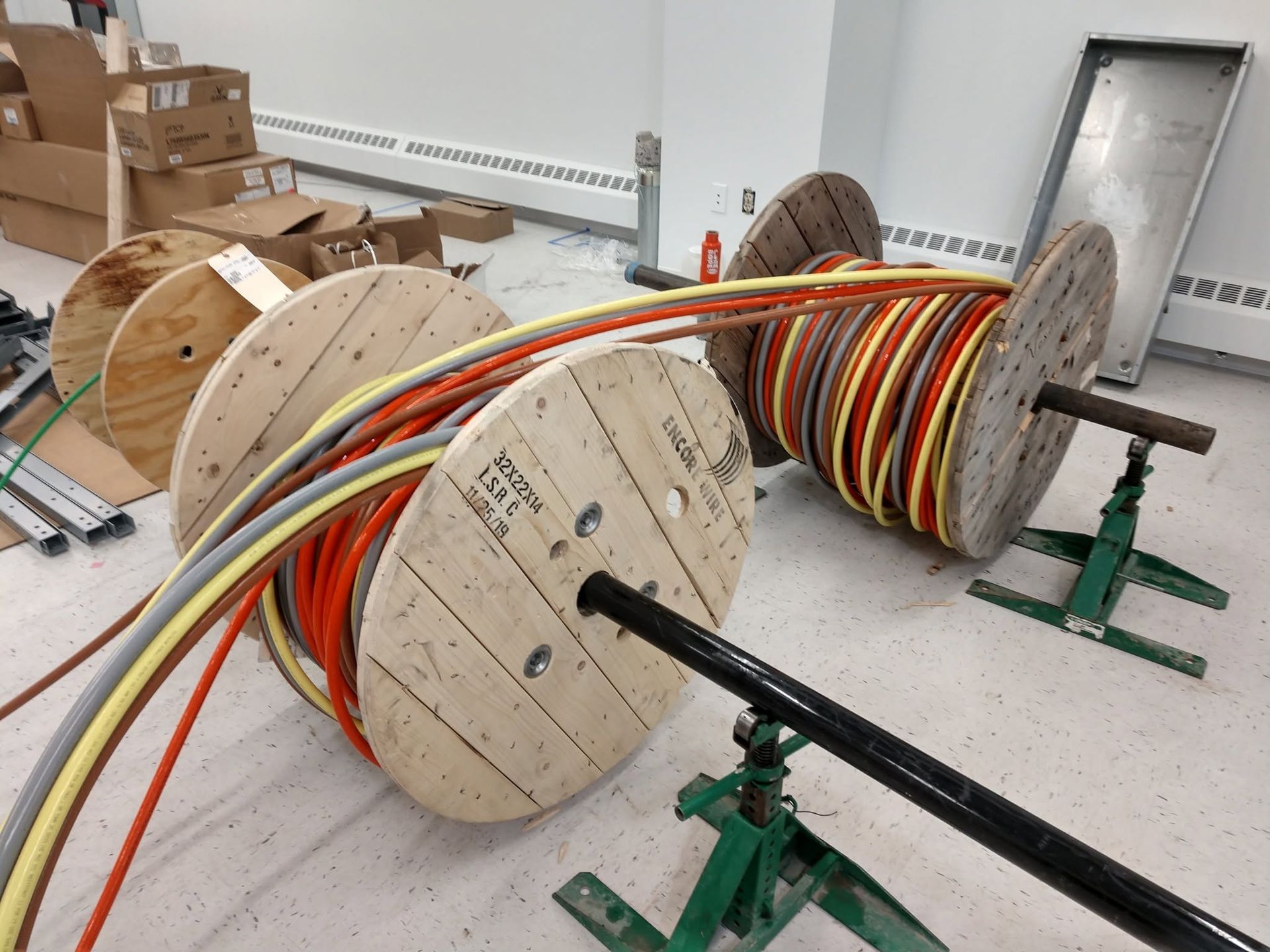 Large wooden cable reels with multicolored cables in a workshop or storage area