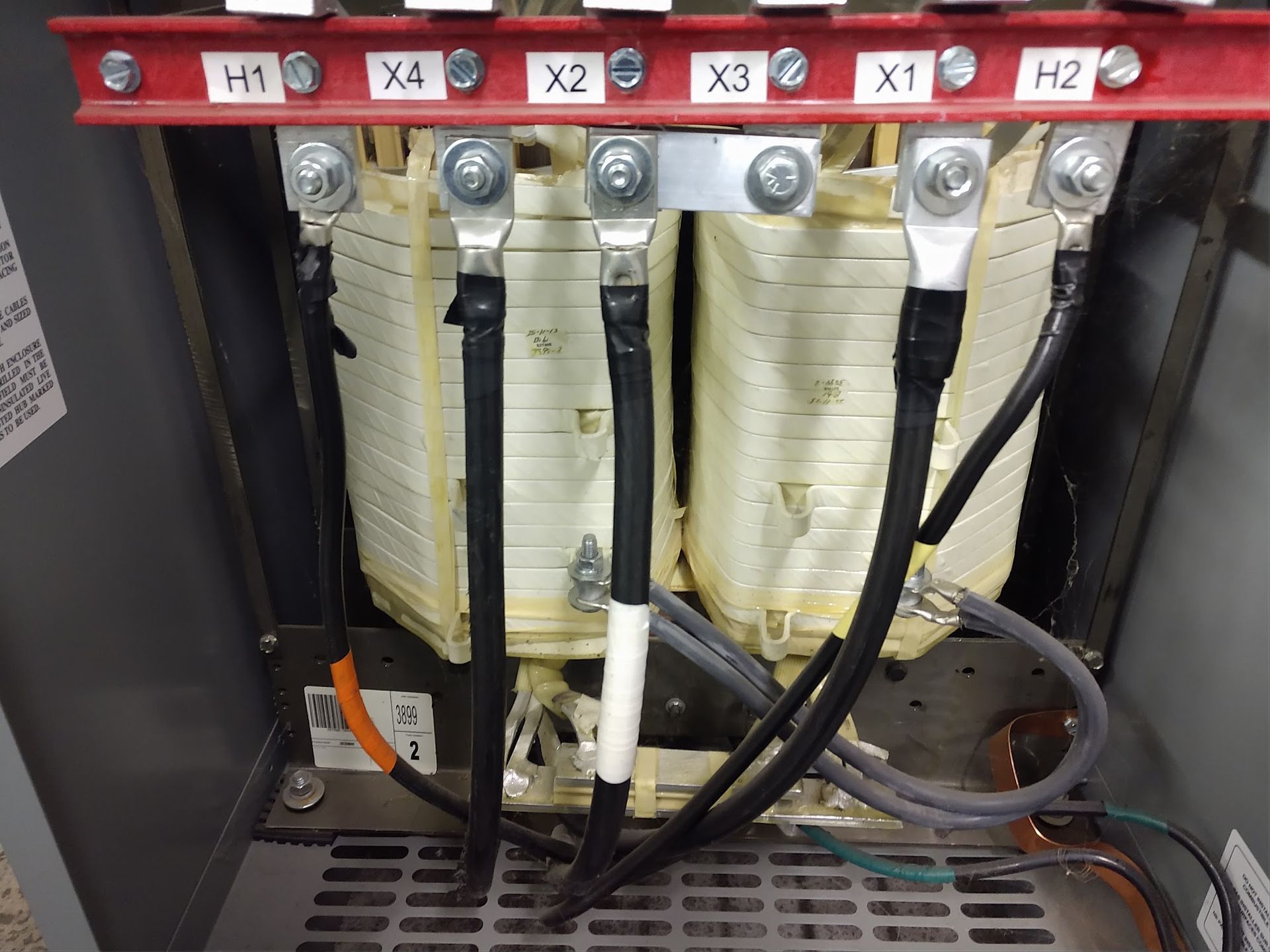Electrical panel interior with labeled fuses, wiring, and components behind a clear cover