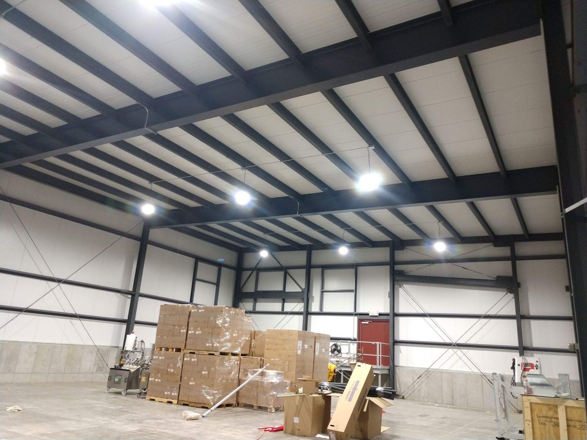 Warehouse interior with stacked boxes and pallets under bright ceiling lights