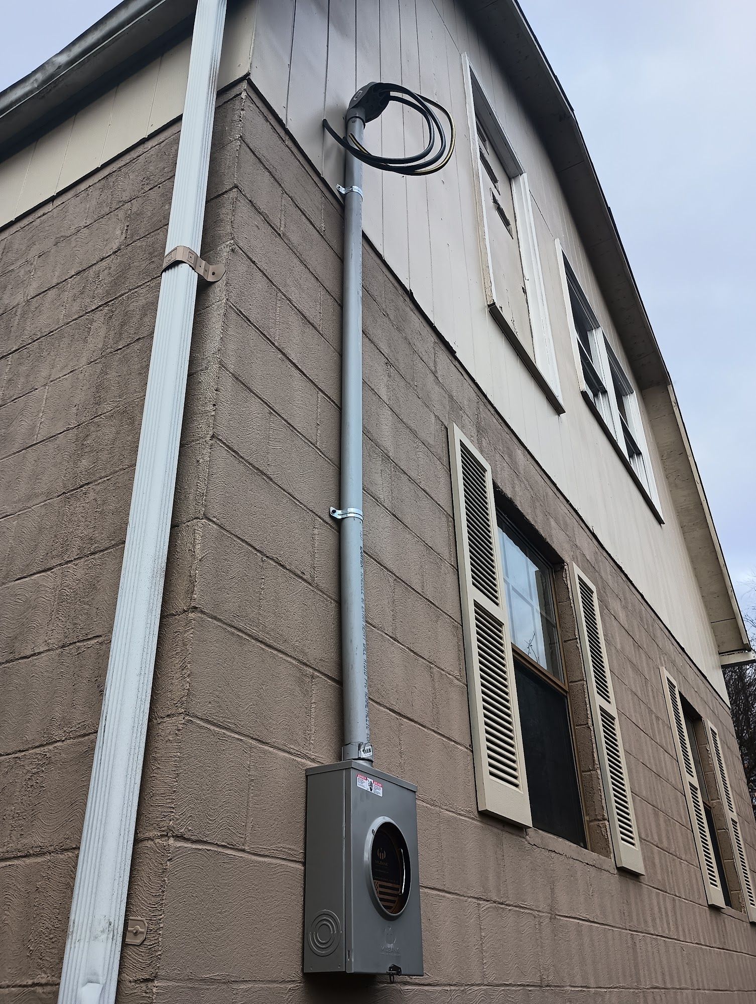 Exterior of a building with a utility meter and conduit mounted on the wall