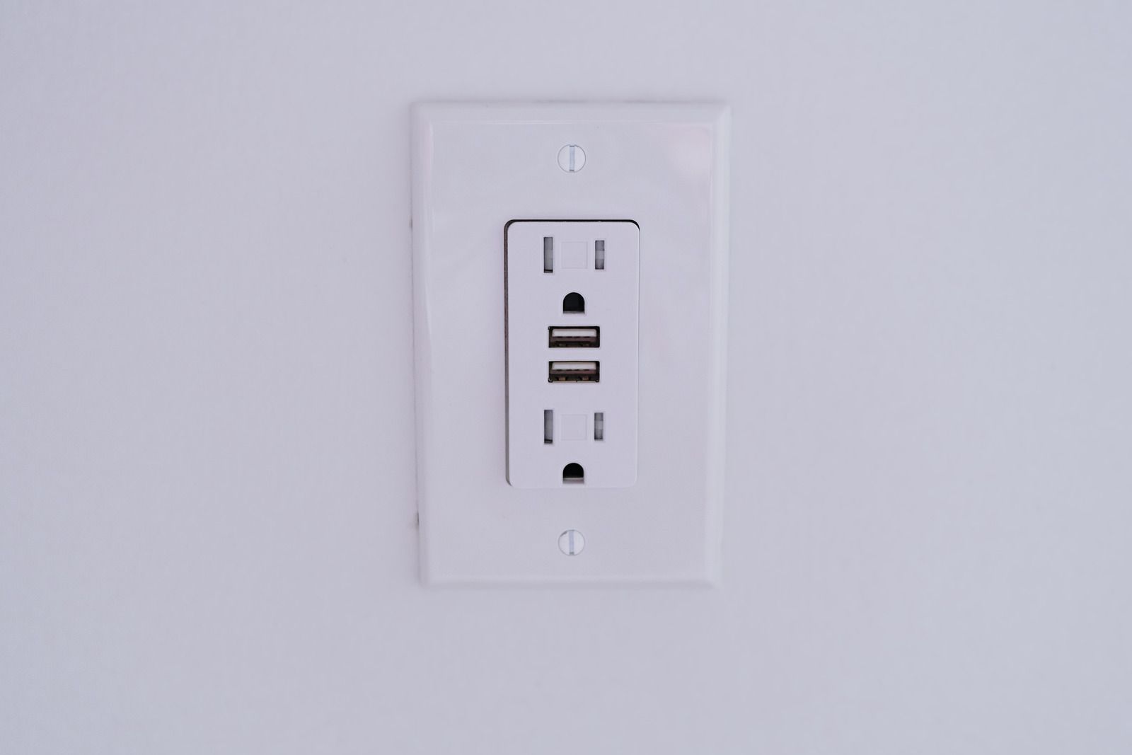 White wall outlet with USB charging ports and electrical sockets.
