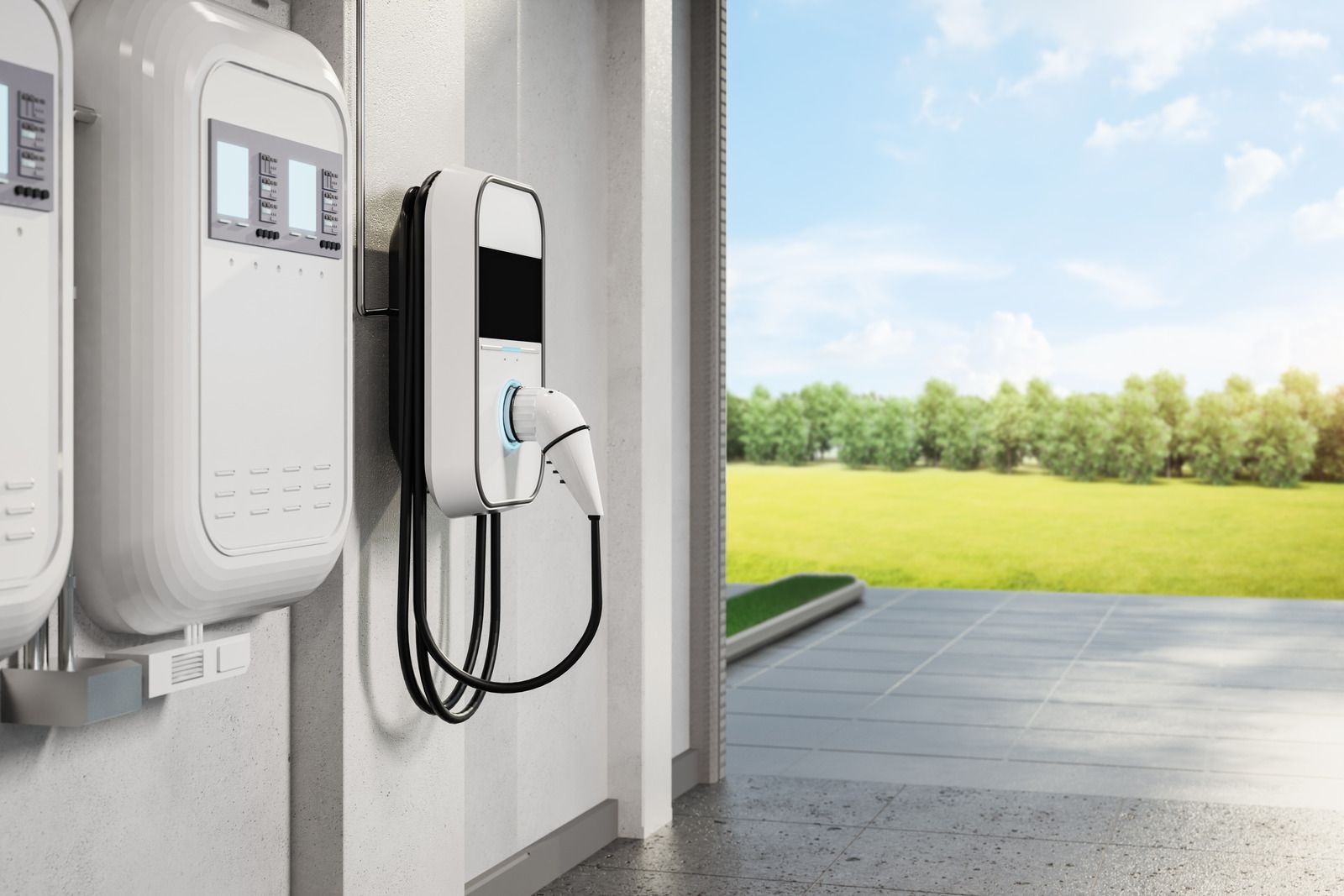 Wall-mounted electric vehicle charging stations in a garage opening to a sunny outdoor driveway