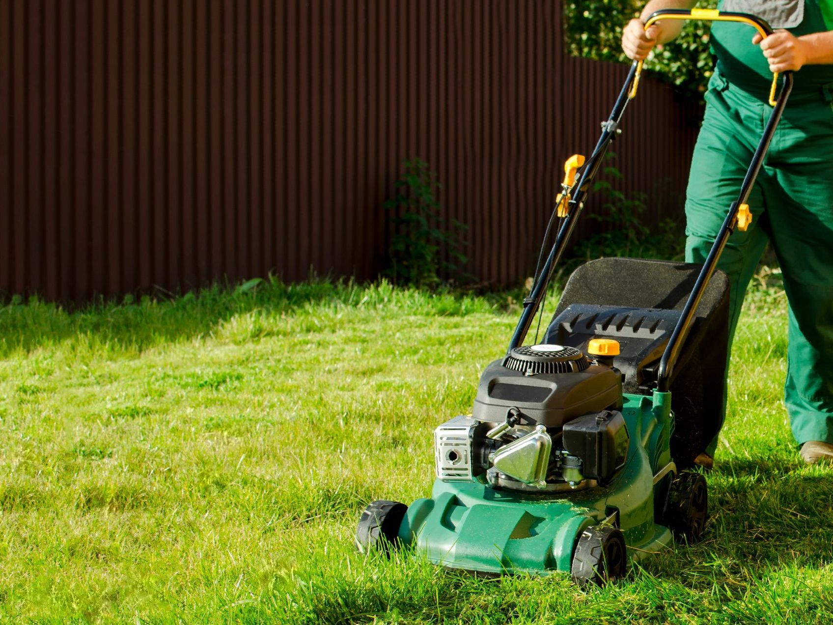 a man is cutting the grass with a lawn mower .