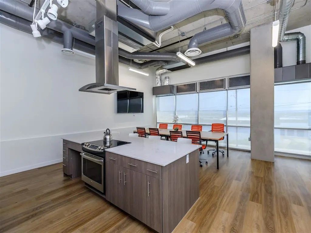 Modern kitchen with island, stove, and a dining table with chairs.