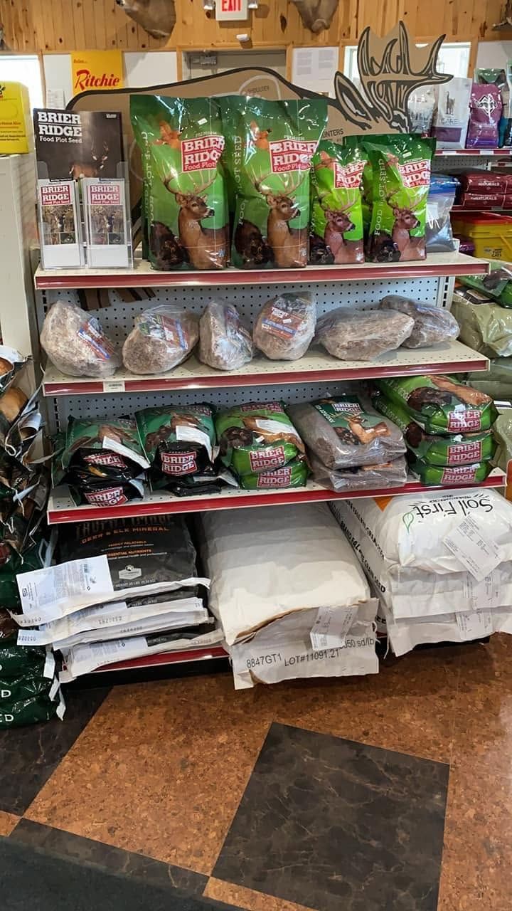 Shelves of assorted packaged goods and folded fabrics in a small shop aisle