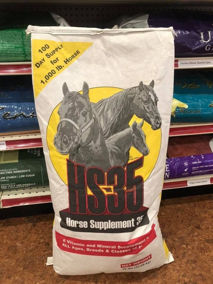 US9 horse supplement bag with two black horses on the front, standing on stacked feed sacks.