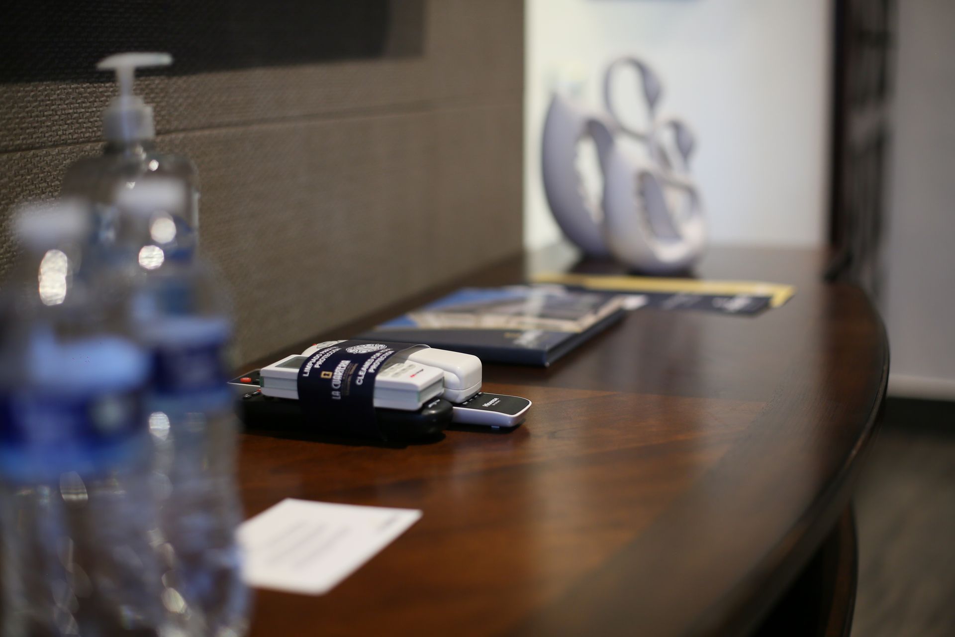 A table with bottles of water and a soap dispenser on it
