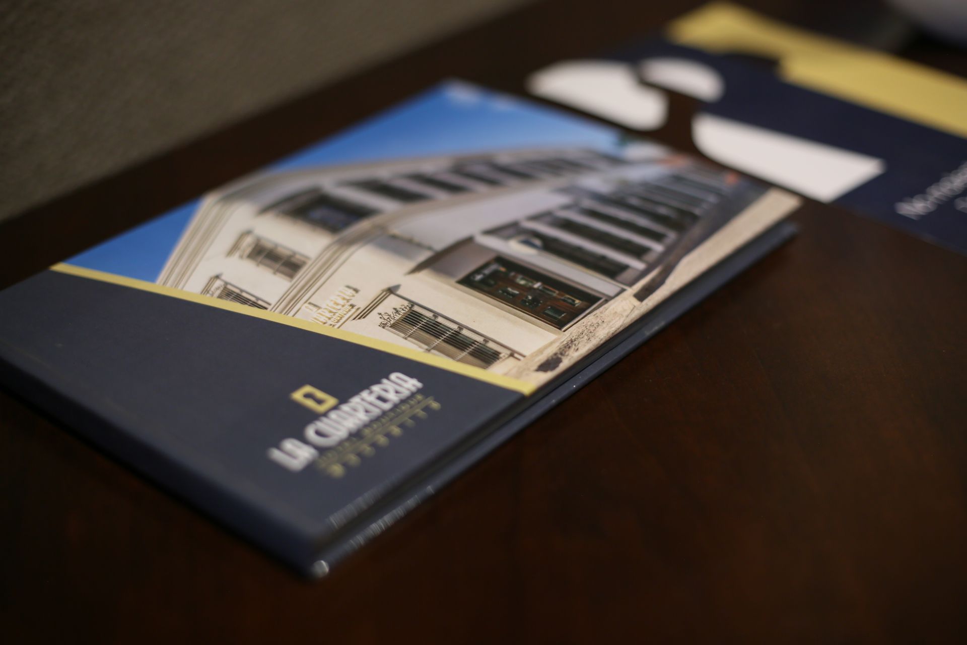 A book with a picture of a house on it is on a table