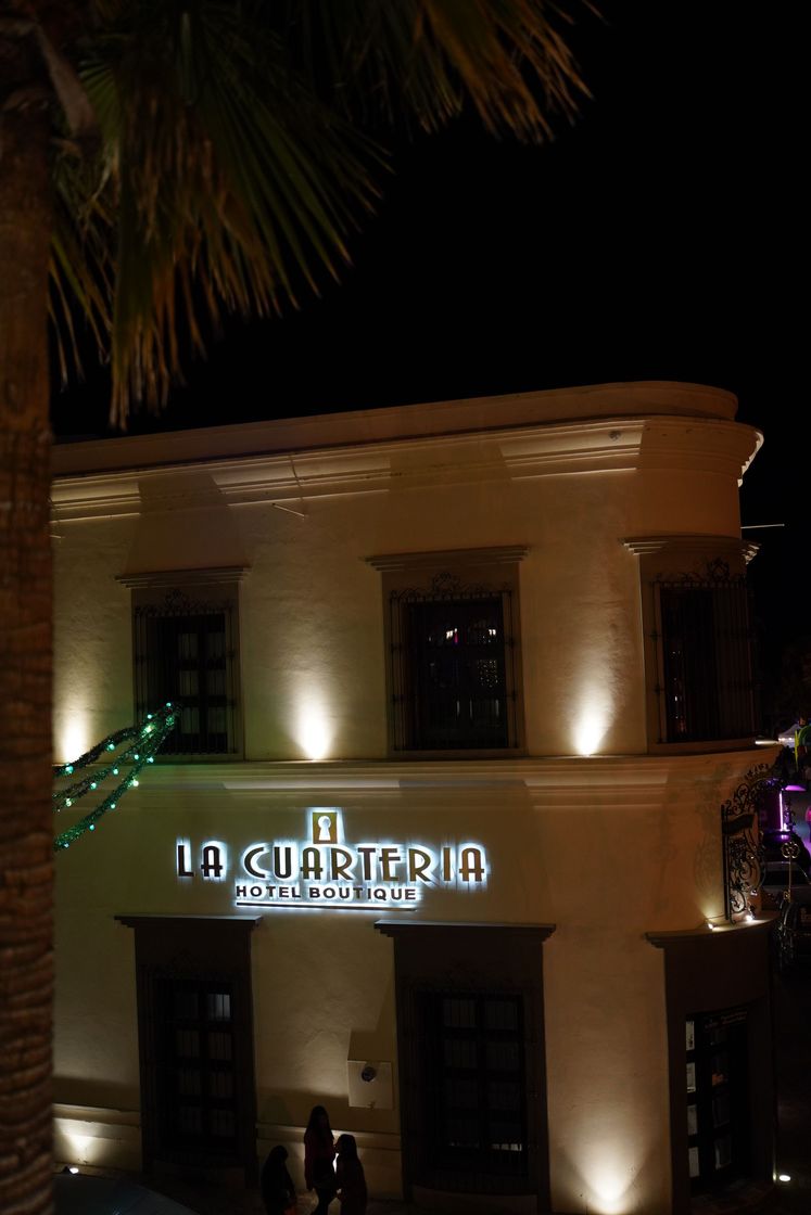 Un edificio blanco con un cartel que dice la cuarteria