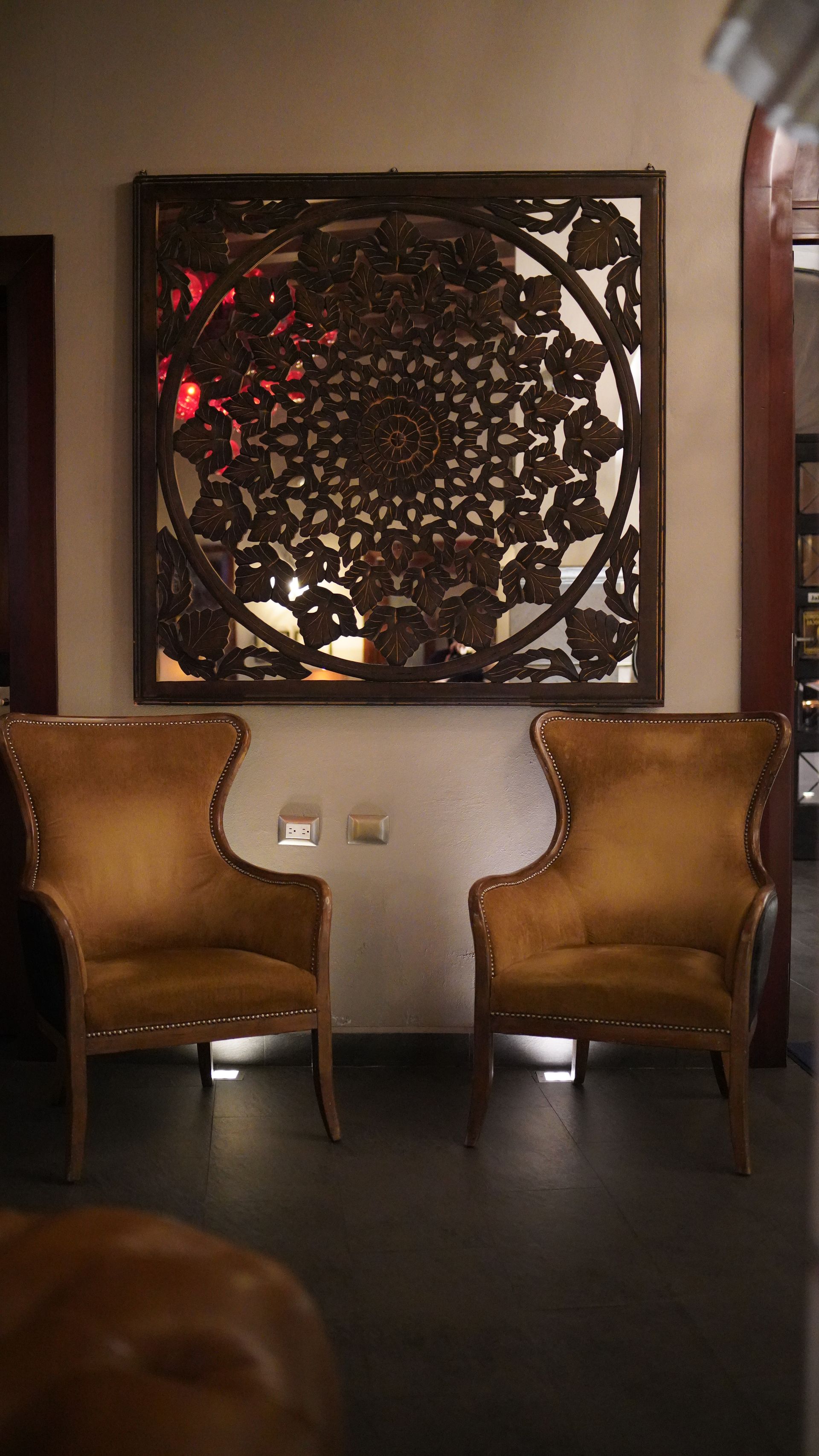 Two chairs are sitting next to each other in a room with a painting on the wall.