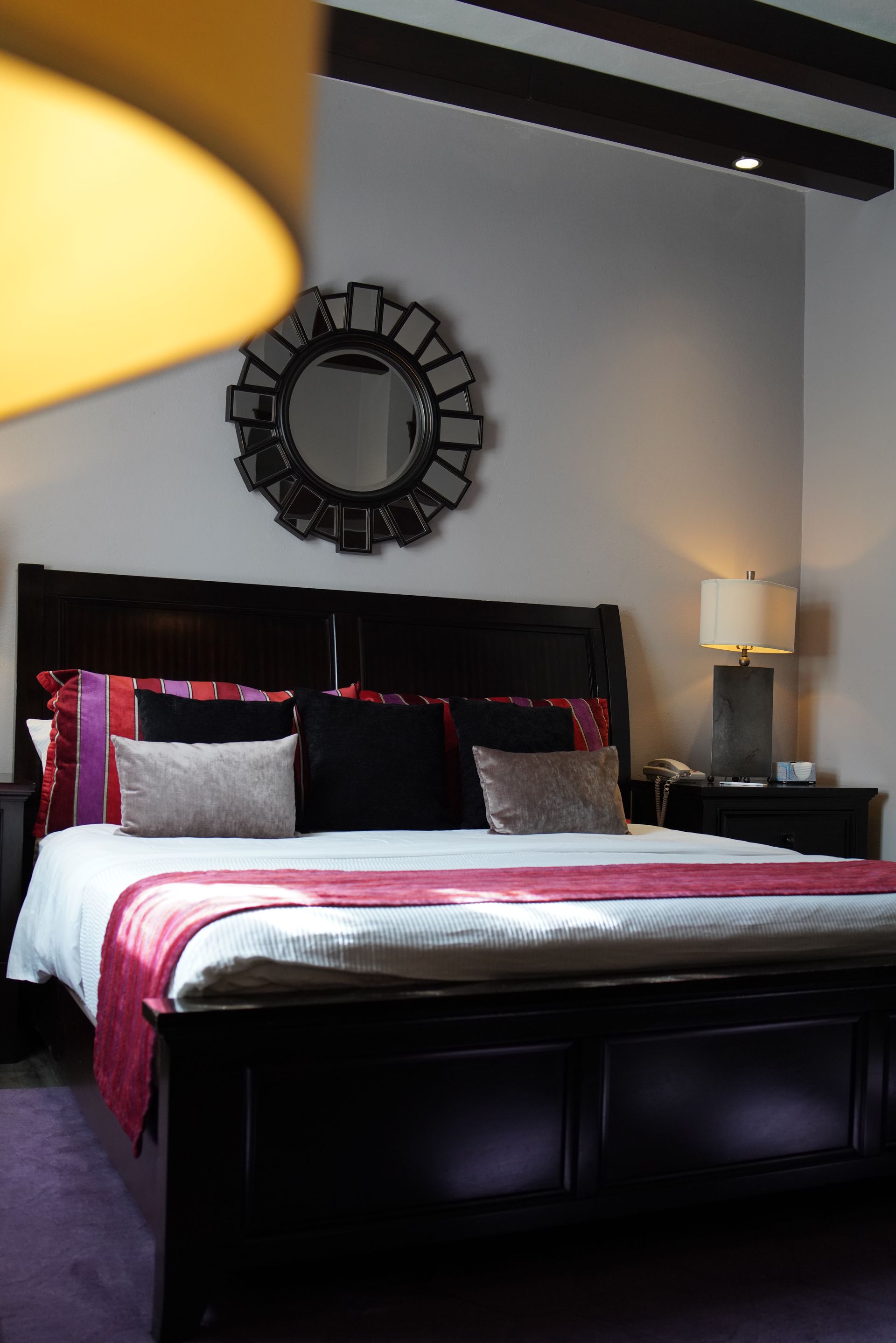 A bedroom with a bed and a mirror on the wall