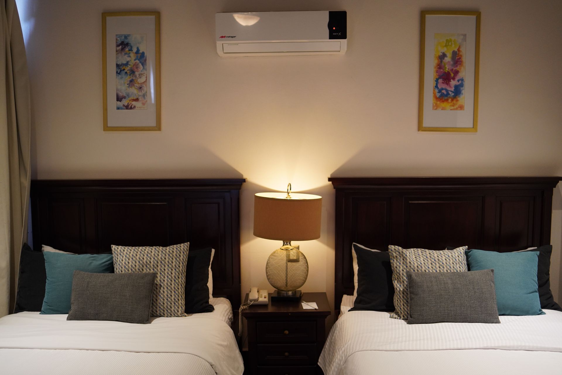 A hotel room with two beds and two lamps
