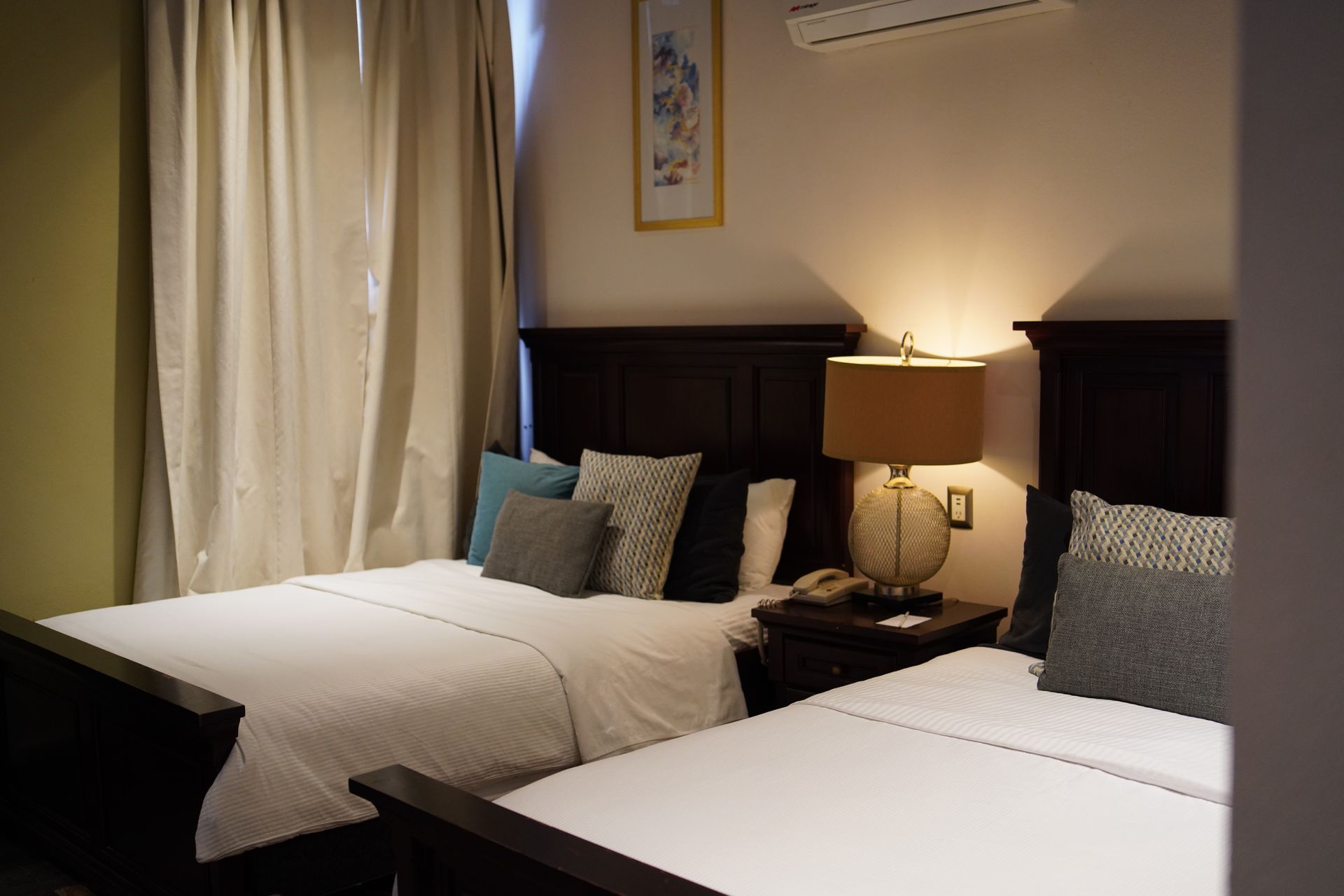 A hotel room with two beds and a lamp