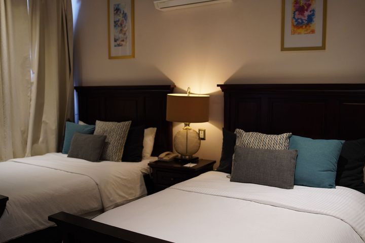 Una habitación de hotel con dos camas y una lámpara.